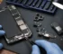 iPhone camera, charging flex and loudspeaker parts arranged with precision tools for repair identification